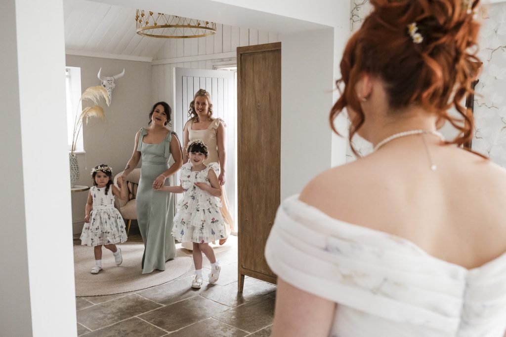 Bridesmaids seeing the bride for the first time on her wedding day.
