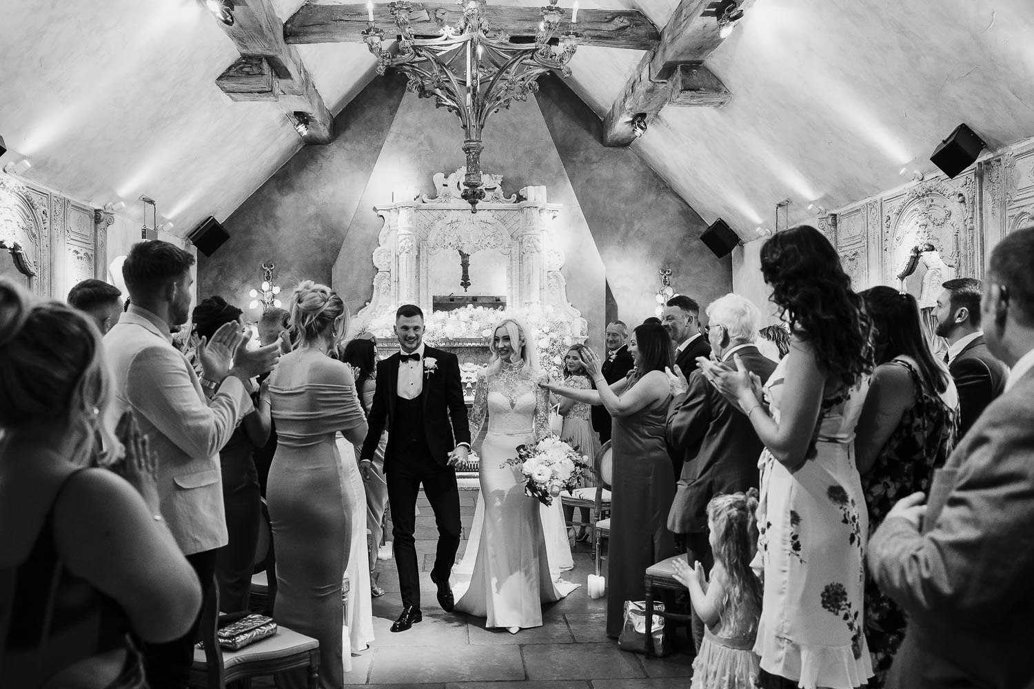 Bride and groom exiting the room in front of their wedding guests after getting married at Le Petit Chateau.