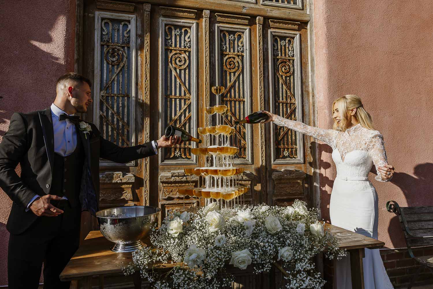 Le Petit Chateau Wedding photography with the couple in front of the red barn with a champagne tower.