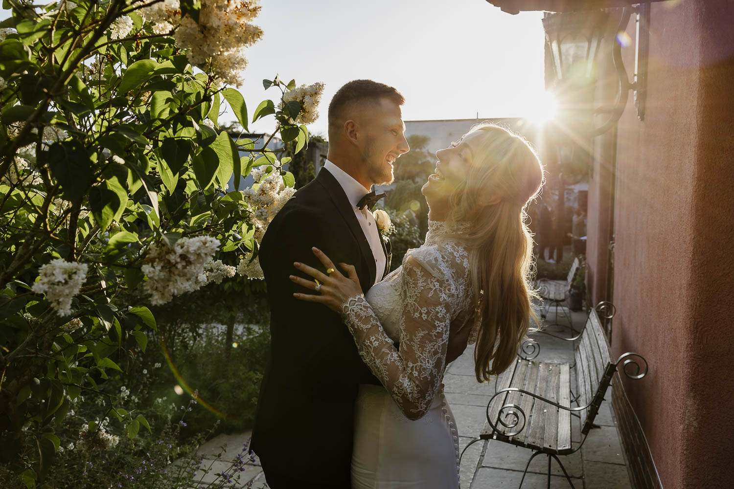 Bride and groom hugging at sunset as the sun comes down