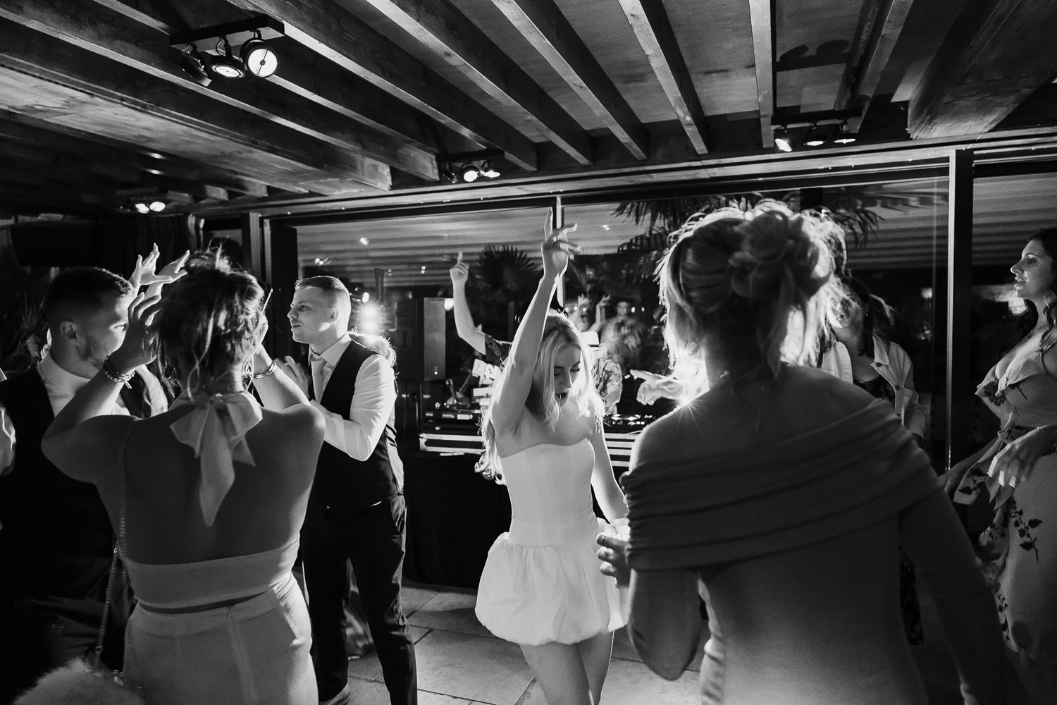 Bride on the dance floor wearing a short evening wedding dress at her wedding.
