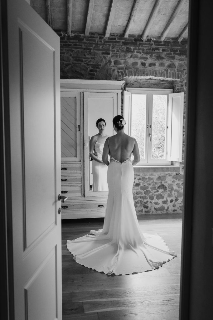 Bride getting into her wedding dress for her wedding at Romignano wine farm in Tuscany