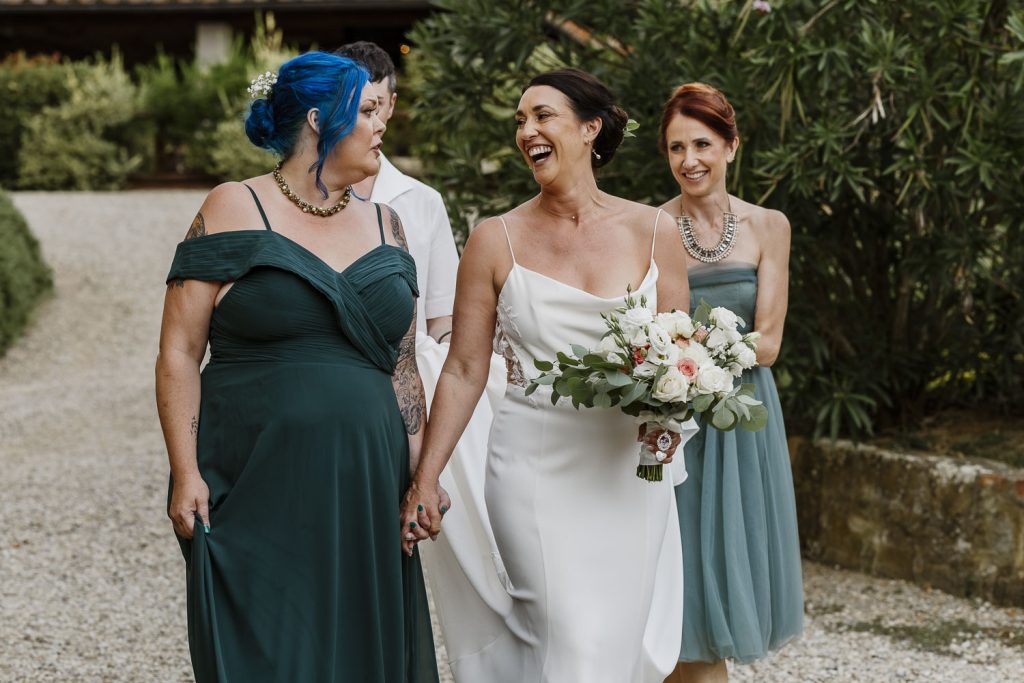 Bride walking to get married at her outdoor wedding ceremony in Tenuta Romignano Wine Farm in Tuscany.