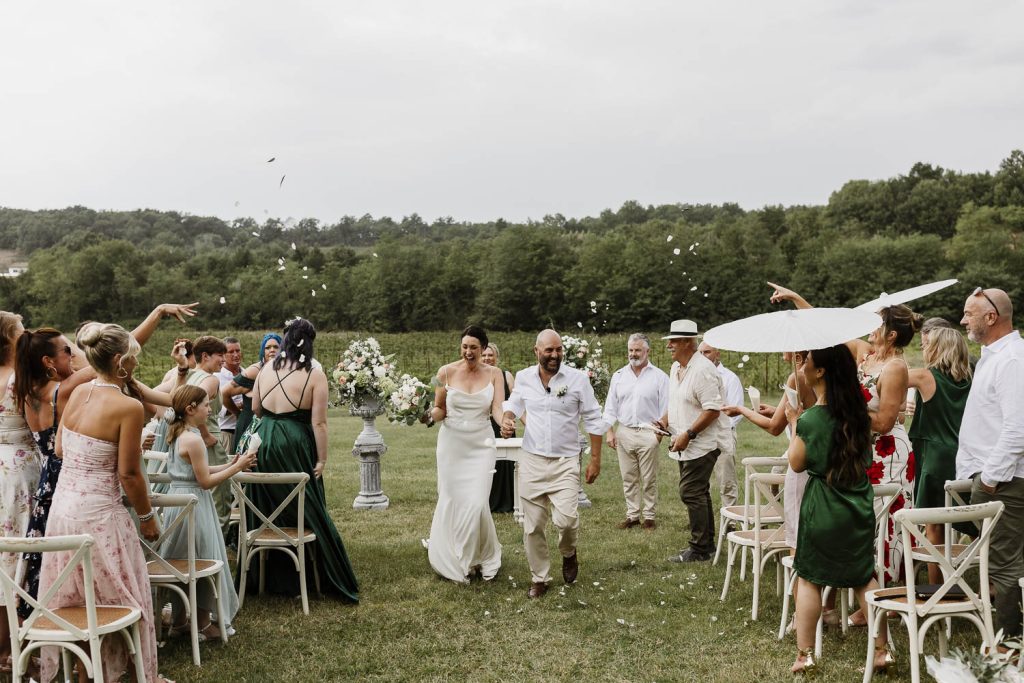 Bride and groom walking up the aisle after their outdoor wedding.