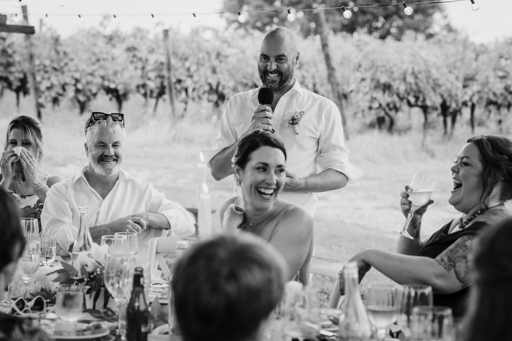 Wedding dining table with the groom doing a speech.