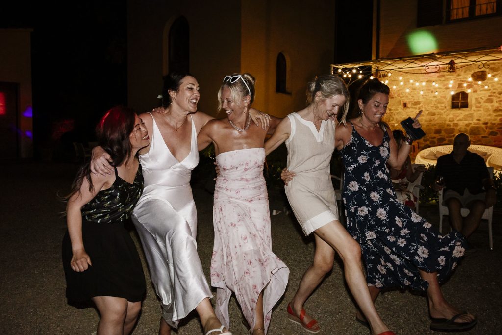 Bride with her girlfriends having fun on the dance floor at Tenuta Romignano wedding.