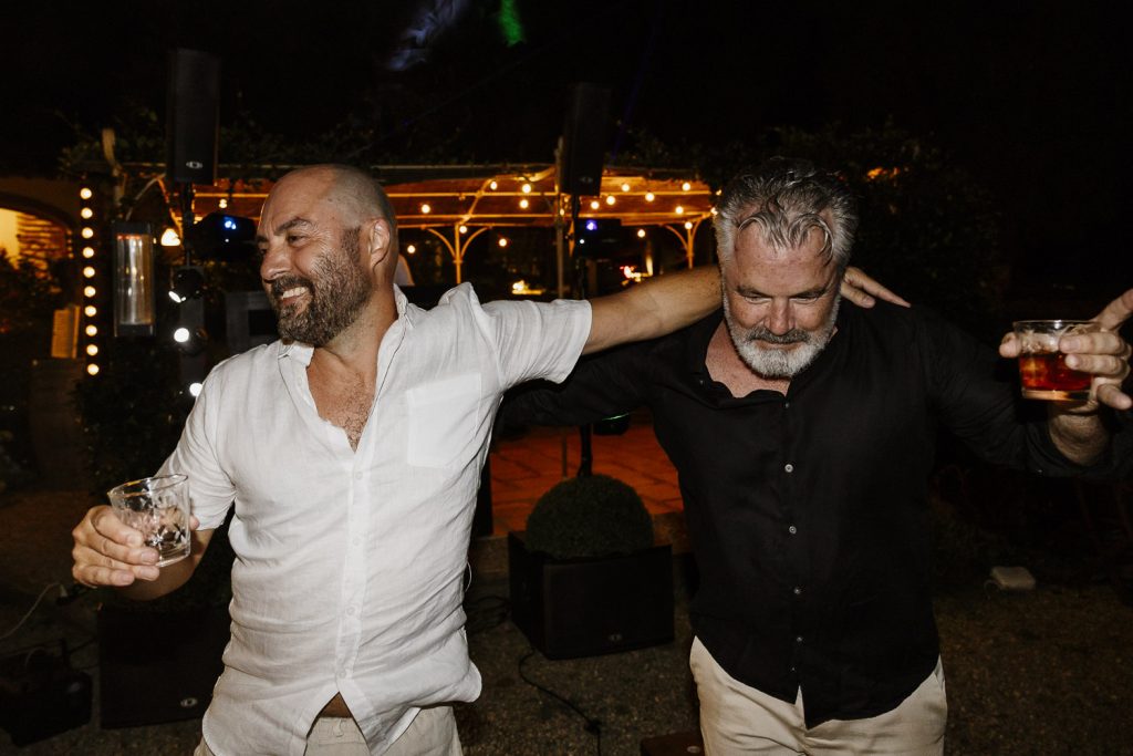 Groom with his friend dancing on the wedding dance floor.