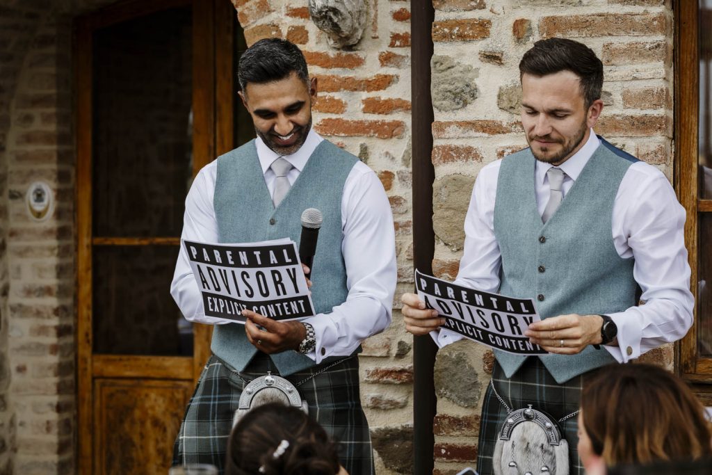 Groomsmen making their speeches with warning signs so not to cause offence.