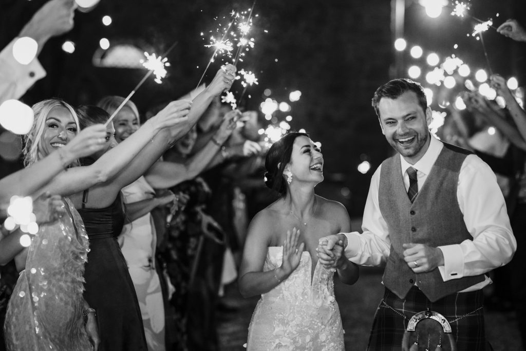 Bride and groom walking down a line of sparklers at Villa San Crispolto in Italy.