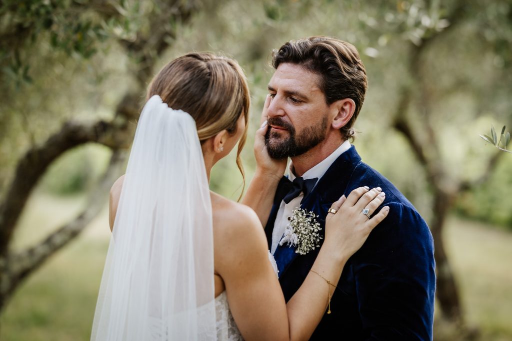 Wedding couple amongst olive groves hugging at sunset for their destination wedding in Italy