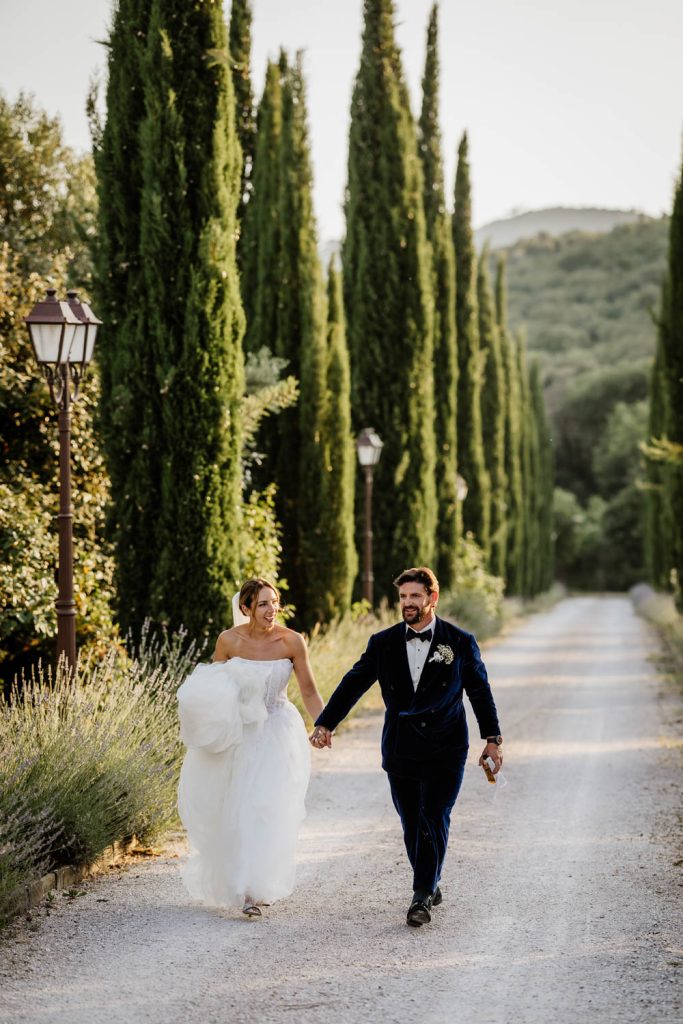 Bride and groom walking up the drive of Villa Baroncino at sunset