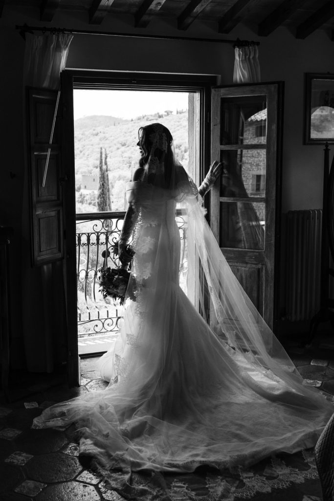 Bride looking out of the balcony window on her wedding day at Villa Baroncino