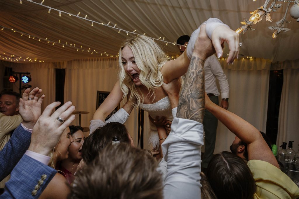 Bride crowd surfing on her wedding day at her Tuscany wedding
