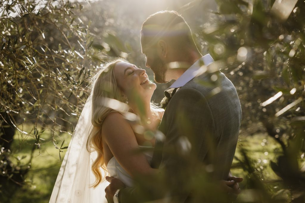 Bride and groom hugging after getting married in the evening light sunset