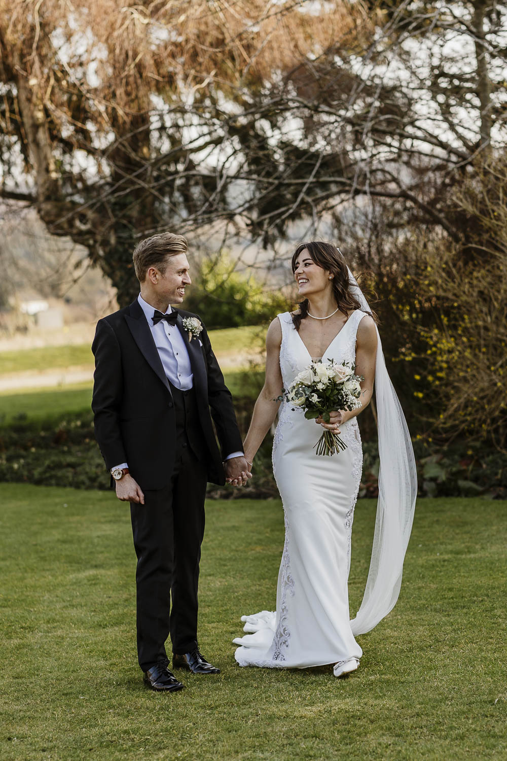 Bride and Groom walking in the Manor House Garden on their wedding day